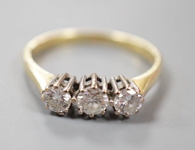 A modern 18ct gold and three stone diamond ring, size O, gross weight 2.5 grams.
